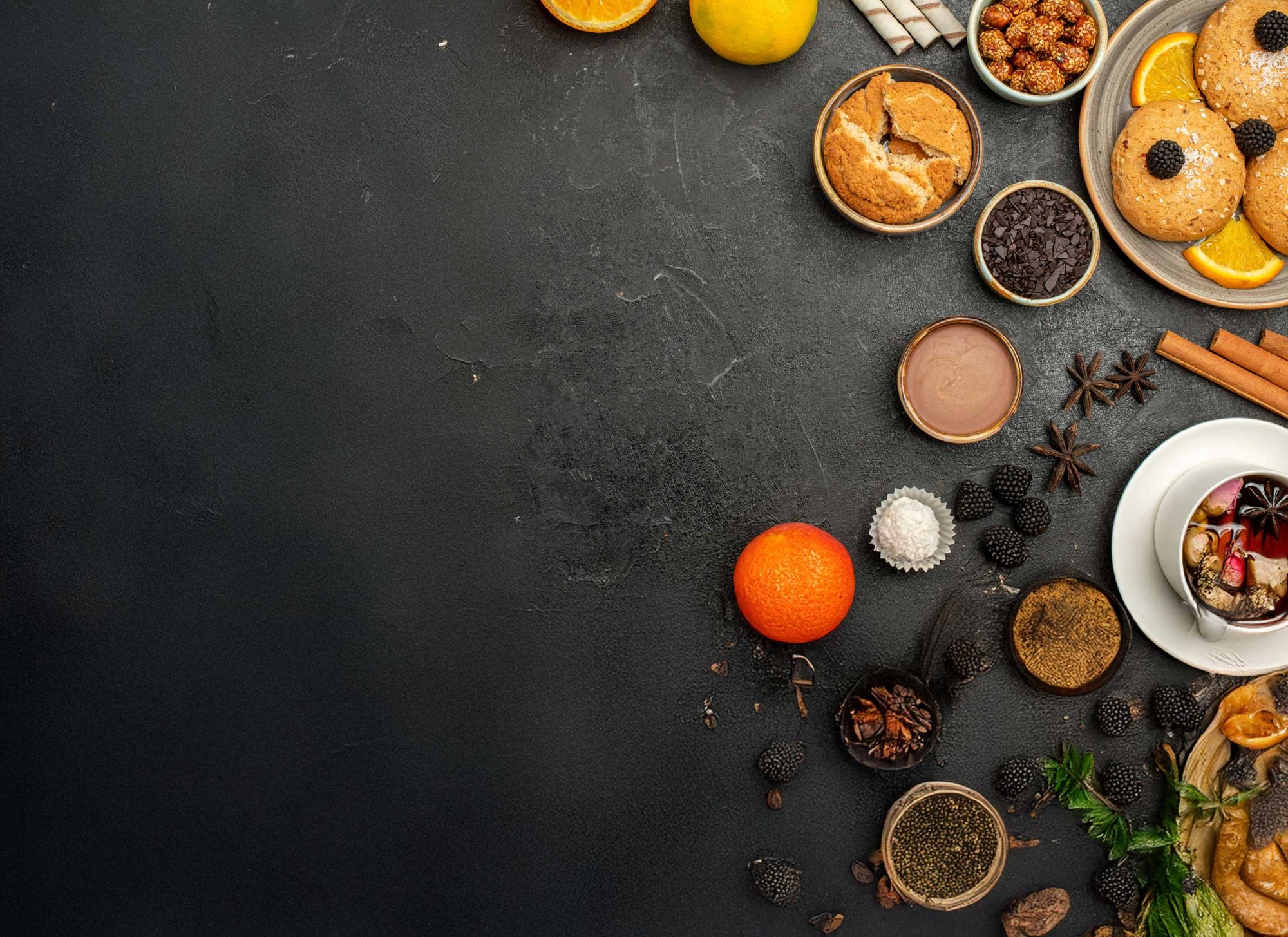 Citrus, spices and sweet ingredients on a dark tabletop