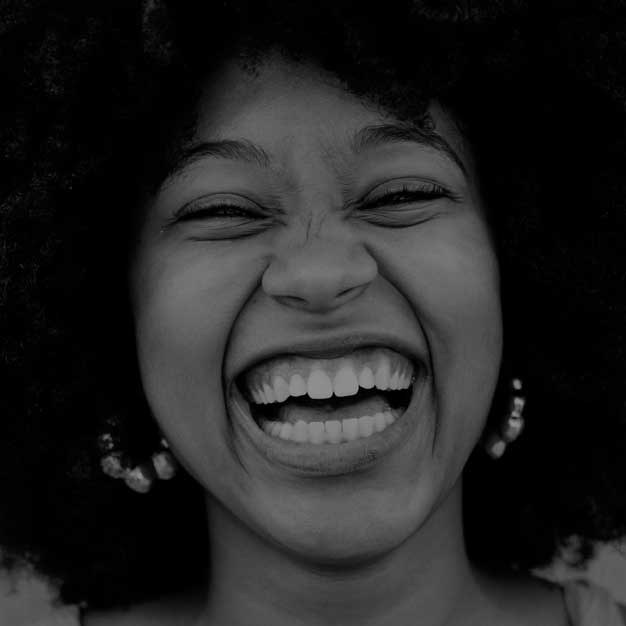 A woman laughing in a black and white portrait